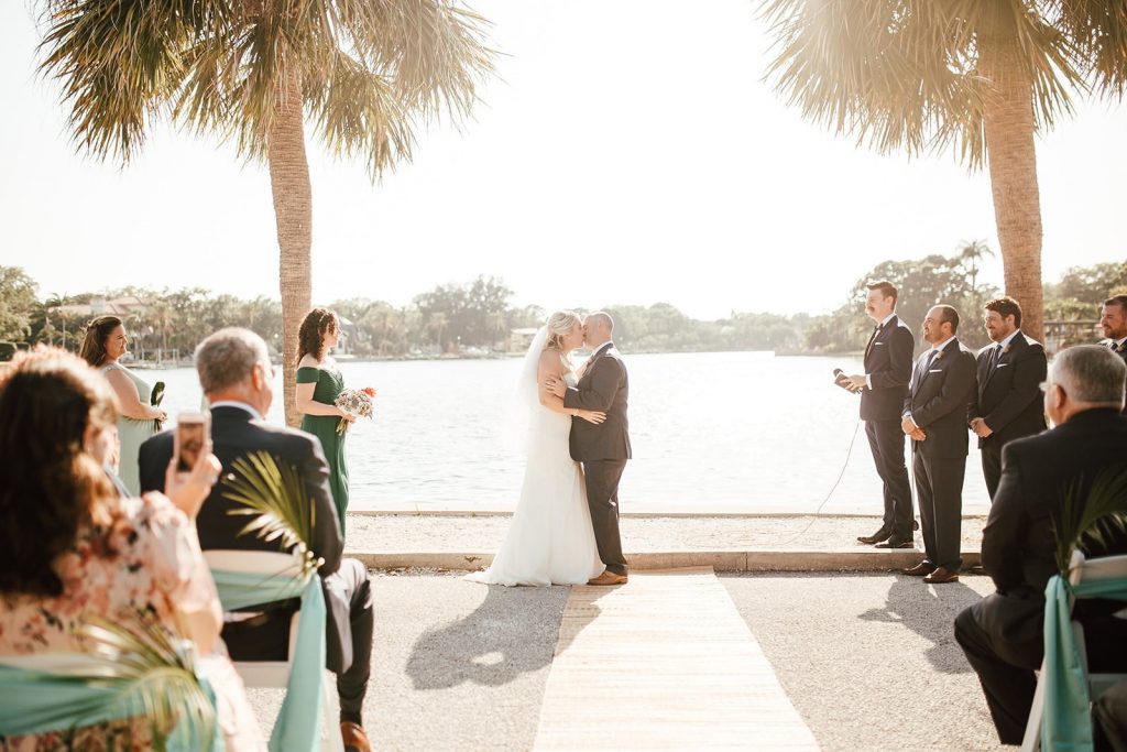 couple kissing at their outdoor waterside wedding