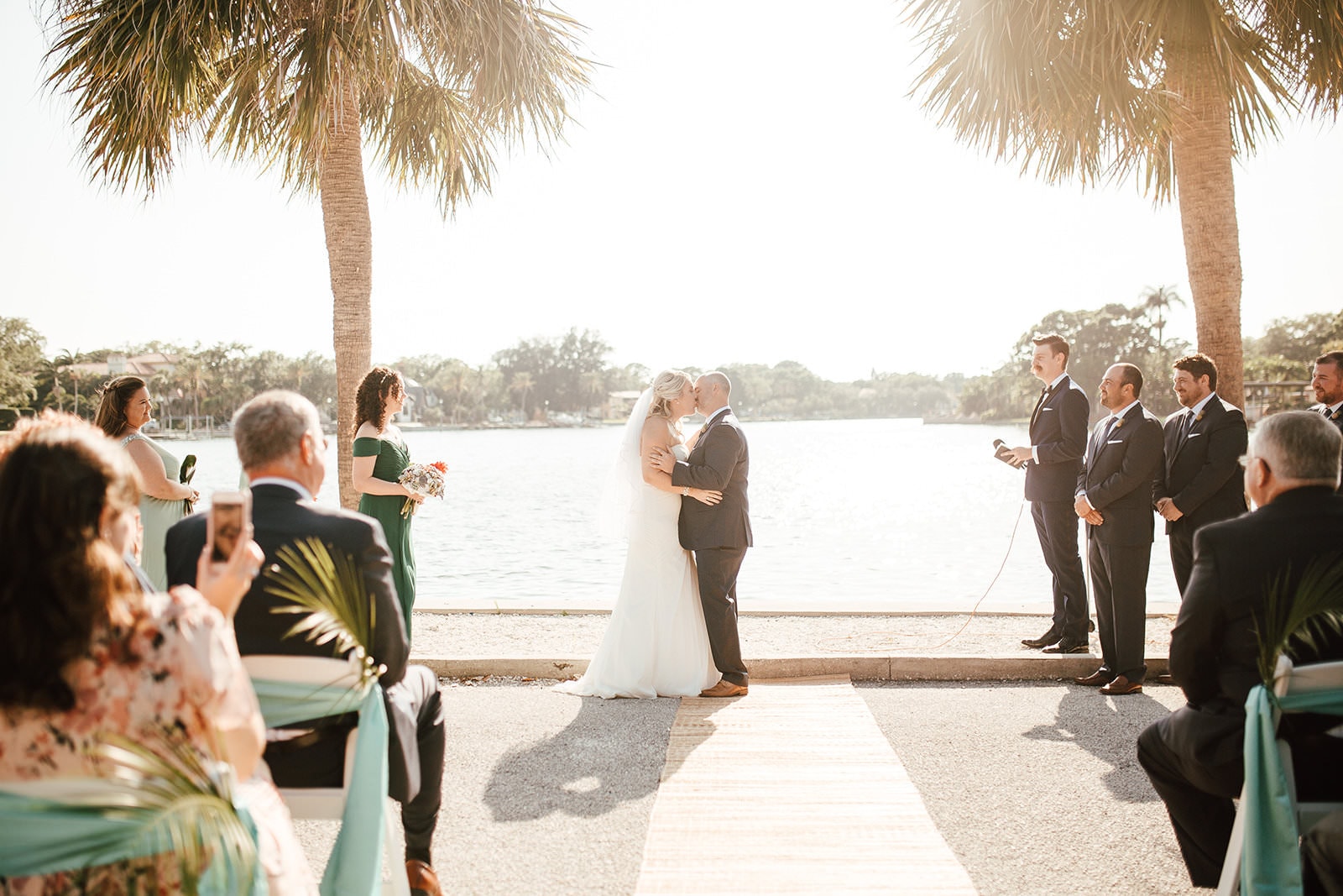 couple kissing at their outdoor waterside wedding