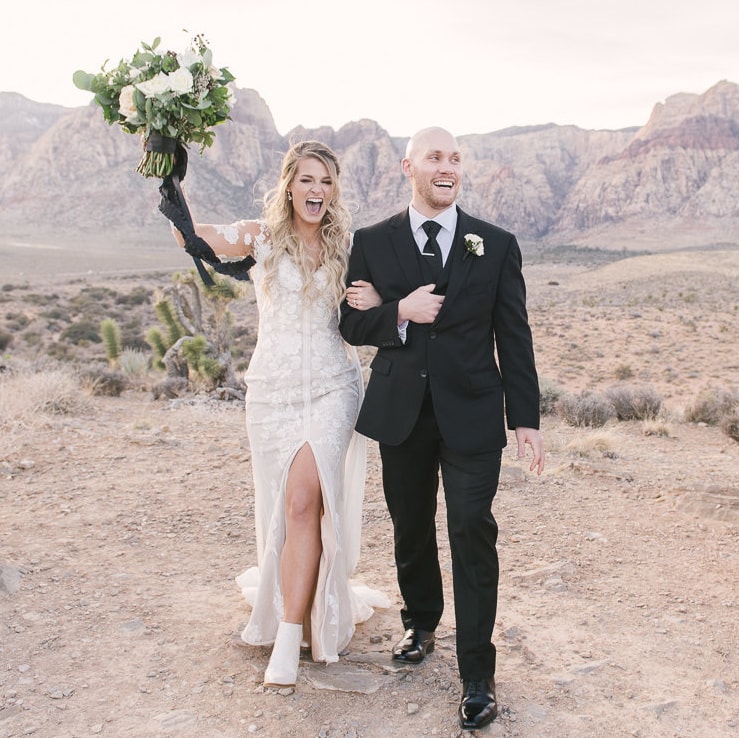 happy couple walking in the desert to get married