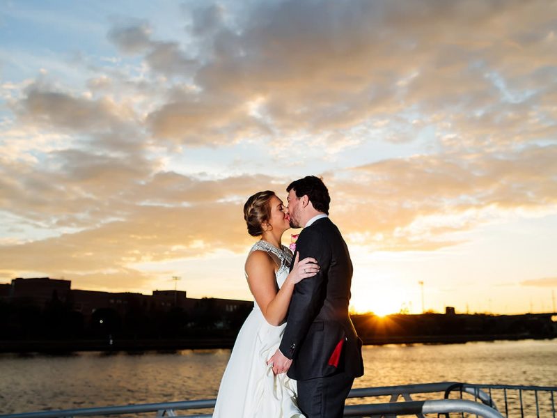 bride and groom at sunset by water