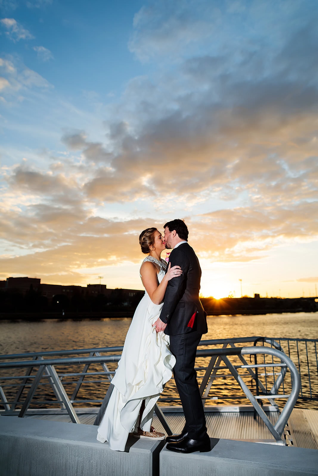 bride and groom at sunset by water