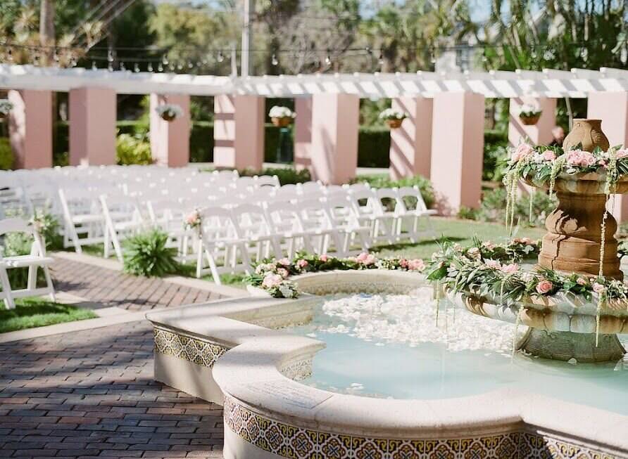 outdoor wedding setup with chairs and pergolas and water fountain