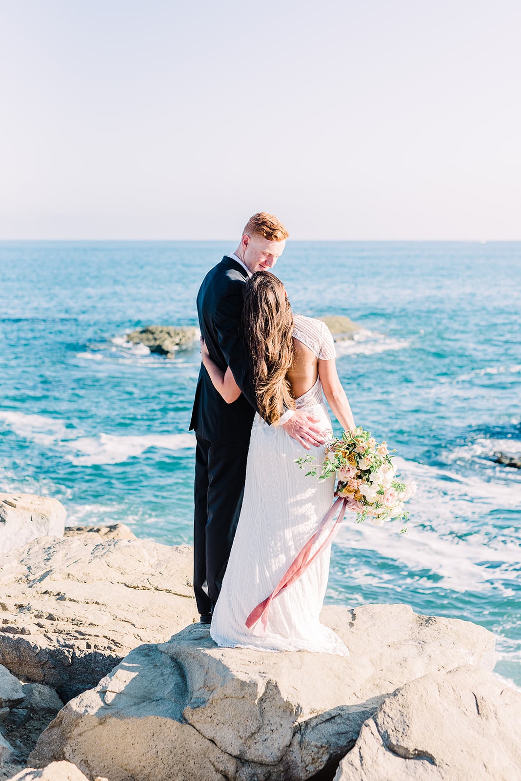 couple taking a moment together on wedding day by ocean