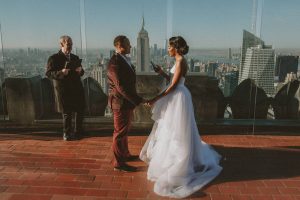 couple reading vows to each other in nyc at top of the rock