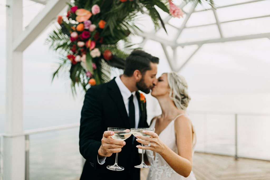 couple kissing and cheersing after wedding
