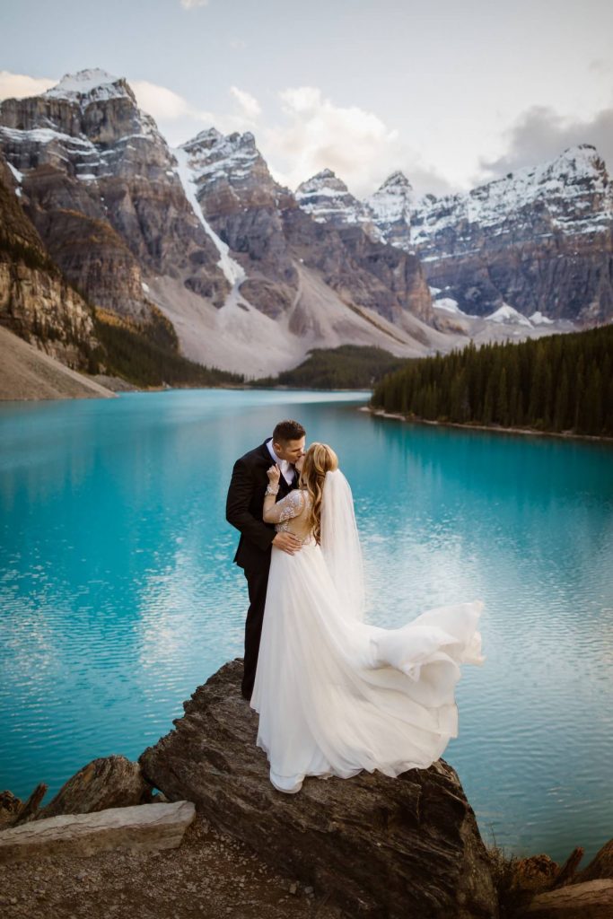 couple eloping in canada at banff with lake and mountains behind them