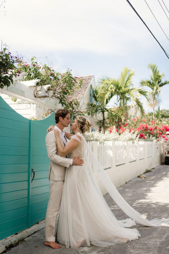 couple eloping in the bahamas teal door behind them
