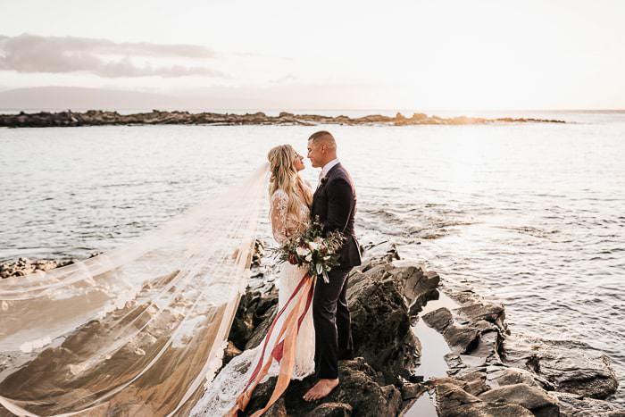 Couple taking wedding photos in Hawaii by the water